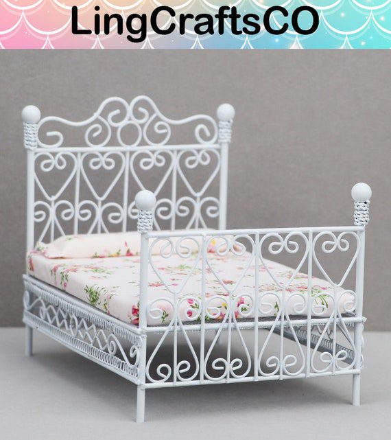 A white bed with a floral pattern on it.